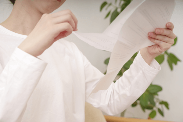 相続登記の書類と住宅ローンの督促状を前に困惑する相続人