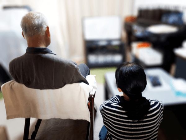 ニュース番組でのリースバック特集を深刻な面持ちで見る高齢者