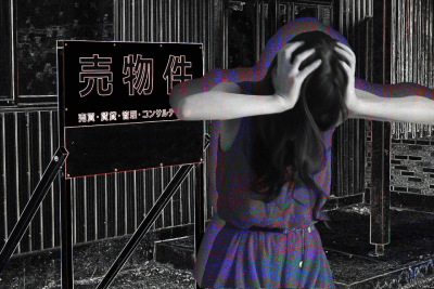 売却中の看板の横で頭を抱える人